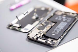 Zoom sur l’arrière d’un iPhone en train d’être examiné pour une réparation par un professionnel.